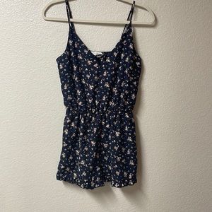 Cute navy blue romper with pink and yellow flower pattern.
